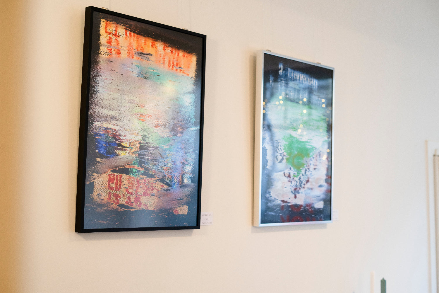 Two framed artworks on a wall with a neutral background