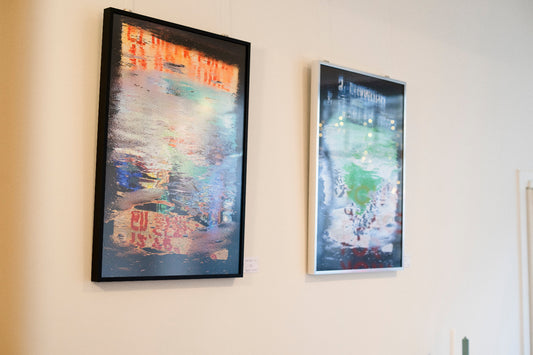Two framed artworks on a wall with a neutral background